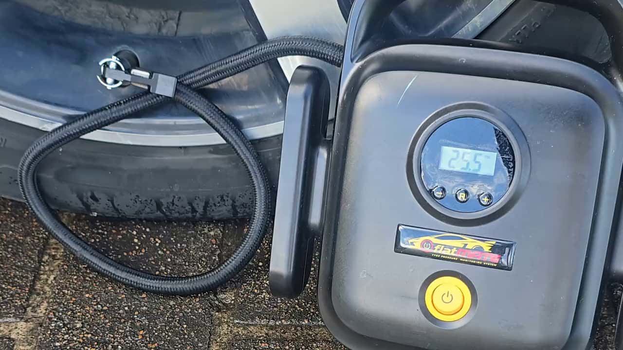 The Surge pump beside a tyre with its hose on the valve.