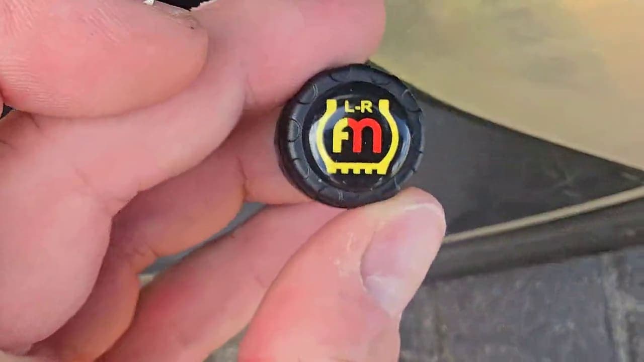 An external tyre sensor held up by hand.