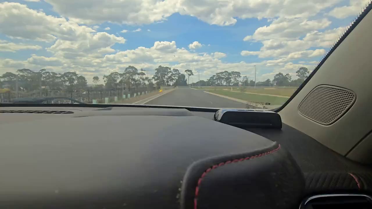 A country road ahead, seen from the driver's seat.